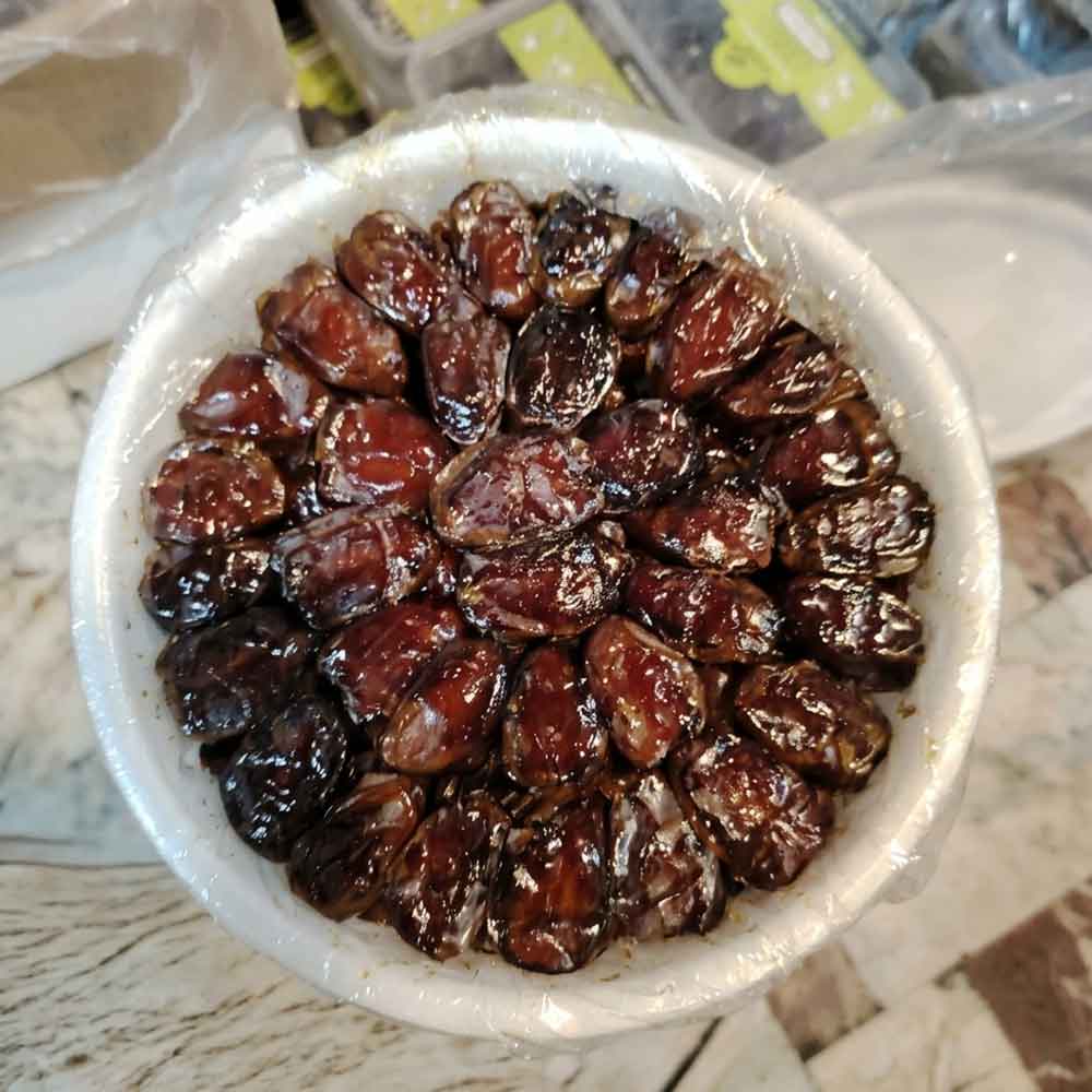 خرید خرمای کبکاب شیره دار در ظرف گرد 1 کیلوگرمی با پوشش سلفون از نمای مایل